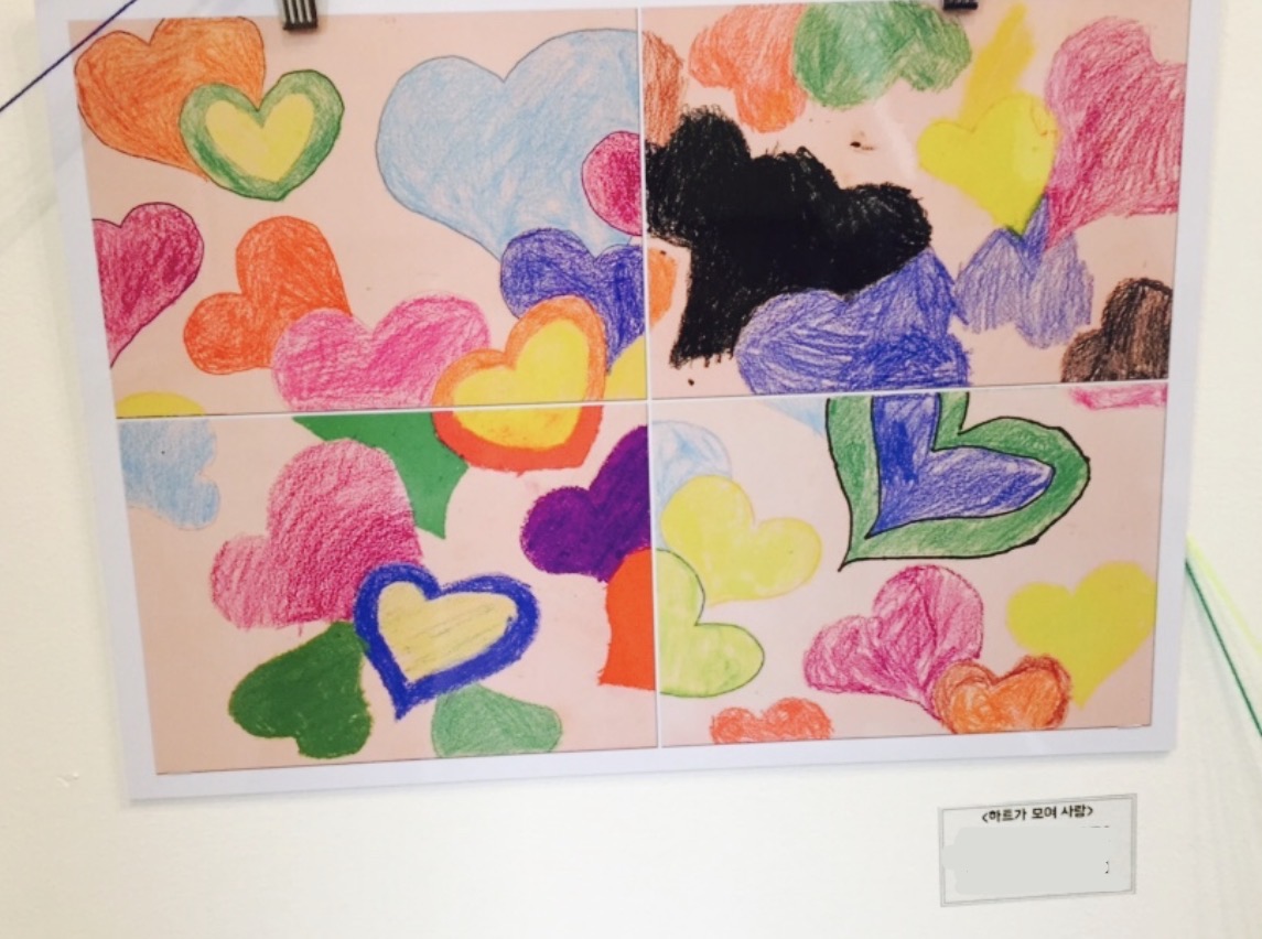 Four student drawings filled with colorful hearts